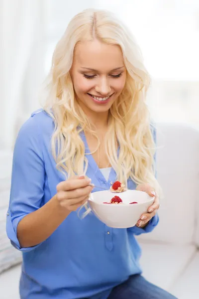 Lachende vrouw met kom muesli ontbijten — Stockfoto