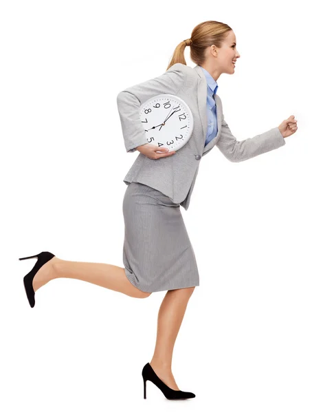 Souriant jeune femme d'affaires avec horloge en marche — Photo