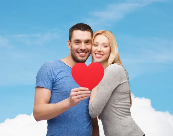 Smiling couple holding big red heart — Stock Photo, Image
