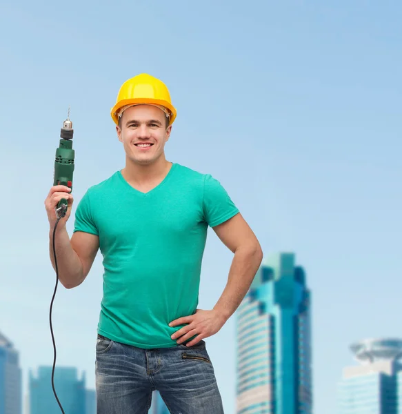 Smiling manual worker in helmet with drill machine — Stock Photo, Image