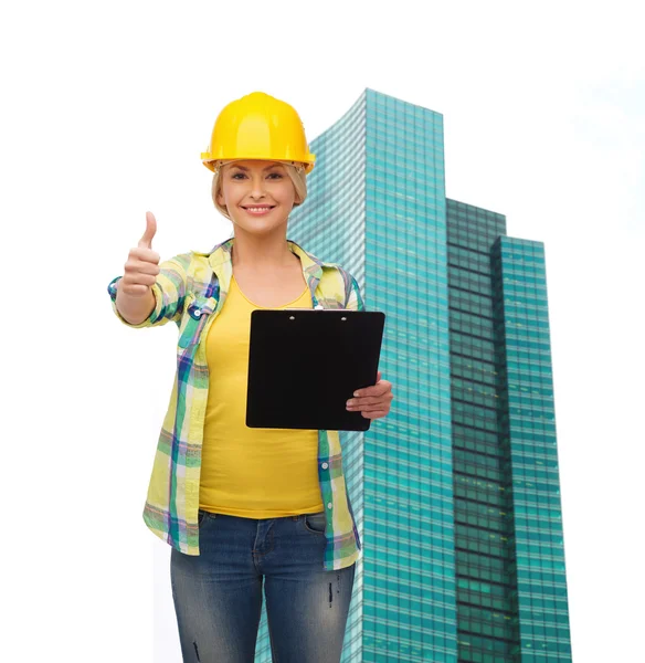 Mujer sonriente en casco con portapapeles — Foto de Stock