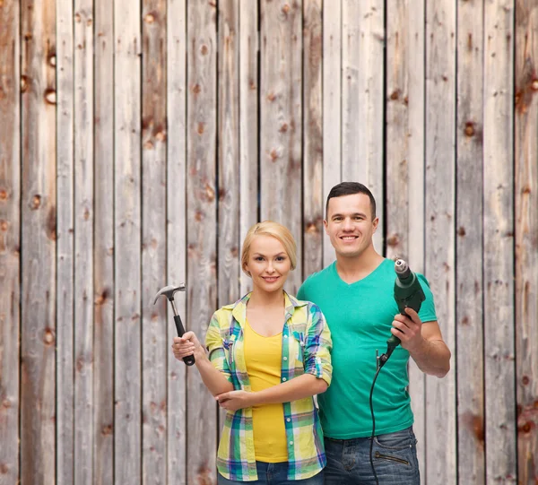 Lächelndes Paar mit Hammer und Bohrer — Stockfoto