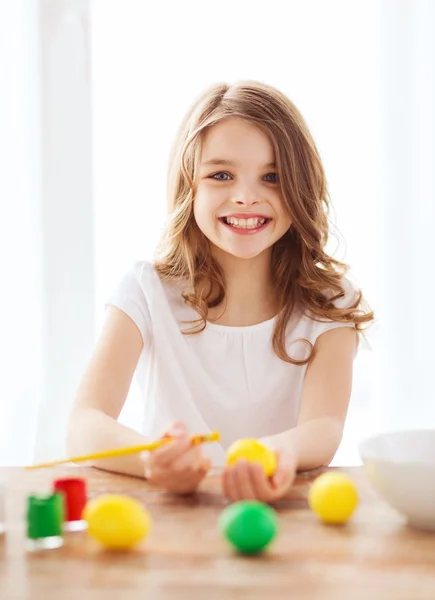 Niña sonriente para colorear huevos para Pascua — Foto de Stock