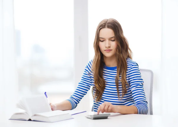 Student meisje met boek, rekenmachine en notebook — Stockfoto