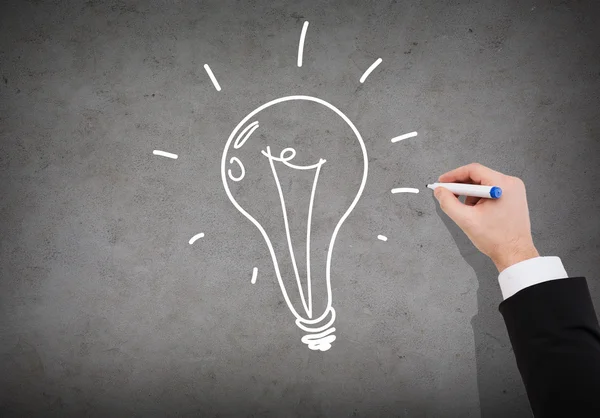 Close up of businessman drawing light bulb — Stock Photo, Image