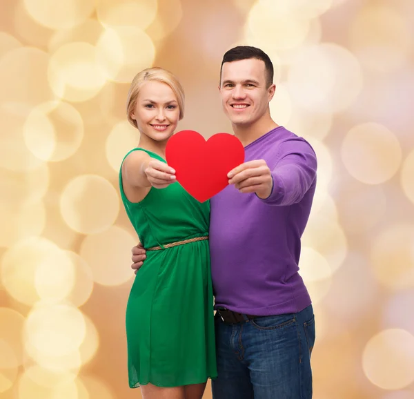 Sonriente pareja sosteniendo gran corazón rojo —  Fotos de Stock