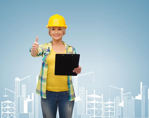 Smiling woman in helmet with clipboard — Stock Photo, Image