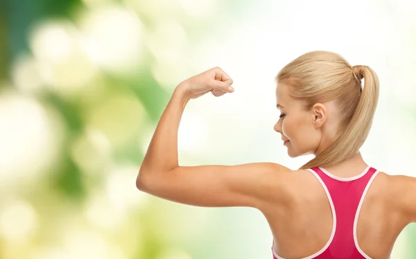 Sportieve vrouw toont haar biceps — Stockfoto