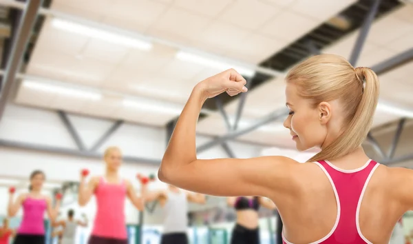 Sportieve vrouw toont haar biceps — Stockfoto