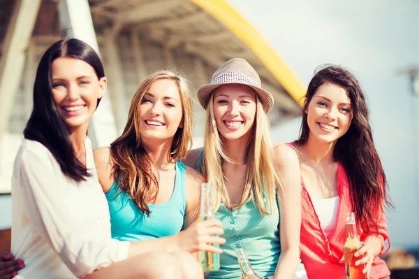 Meisjes met dranken op het strand — Stockfoto