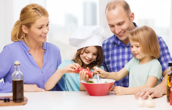 Счастливая семья с двумя детьми готовит ужин дома — стоковое фото