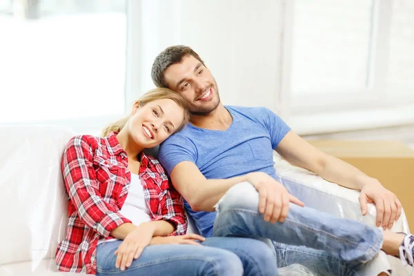 Усміхнена пара розслабляється на дивані в новому будинку — стокове фото