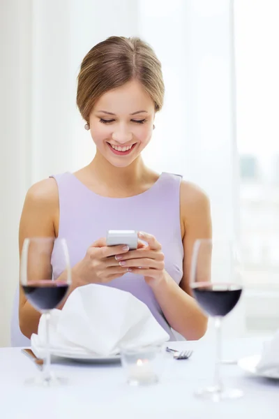 Mulher sorridente com smartphone no resturant — Fotografia de Stock