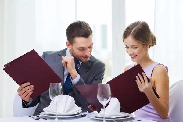 Couple souriant avec menus au restaurant — Photo