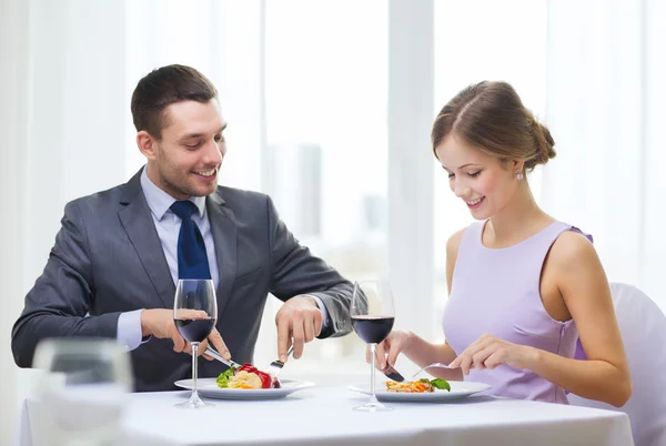 Coppia sorridente mangiare portata principale al ristorante — Foto Stock