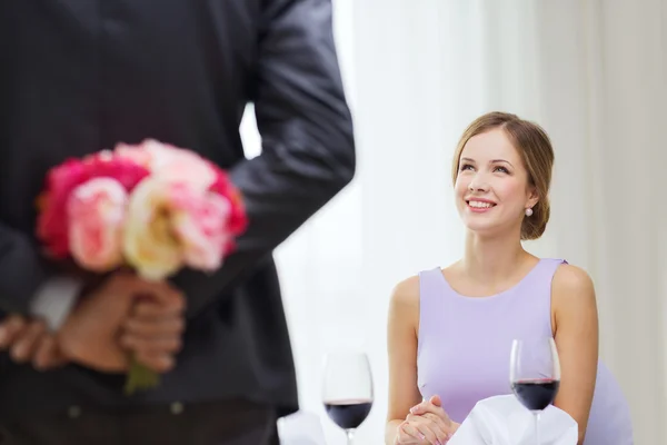 若い女性の花の花束を持つ男を見て — ストック写真