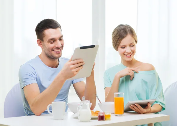 Pareja sonriente con tableta pc noticias de lectura — Foto de Stock