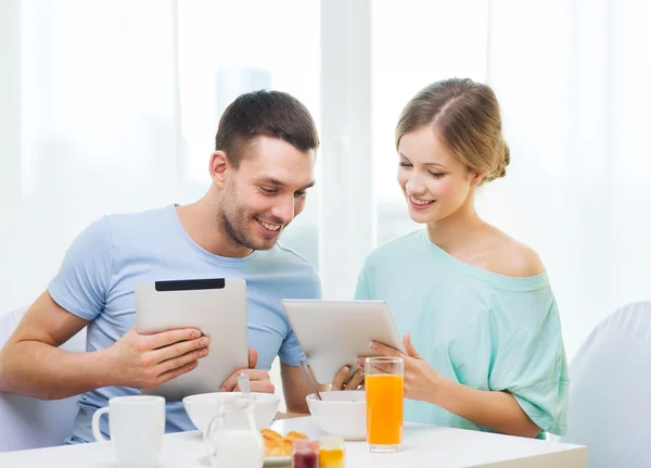 Smiling couple with tablet pc reading news — Stock Photo, Image