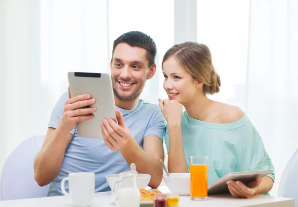 Pareja sonriente con tableta pc noticias de lectura — Foto de Stock