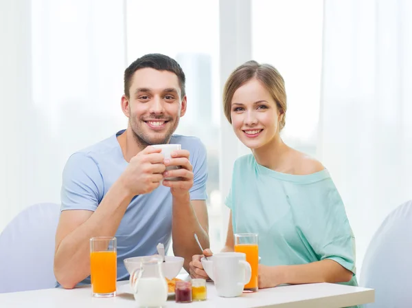 Pareja sonriente desayunando en casa — Foto de Stock