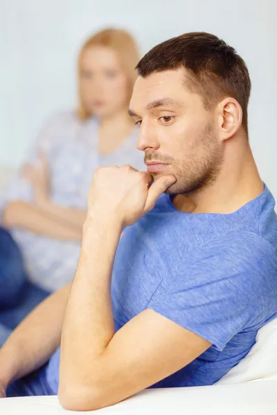 Upset young man with man on the back at home — Stock Photo, Image