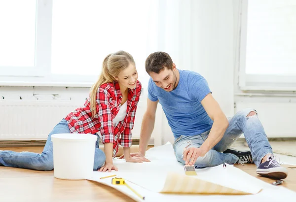 Smiling couple smearing wallpaper with glue — Stock Image Smiling couple smearing wallpaper with glue Royalty Free Stock Photos