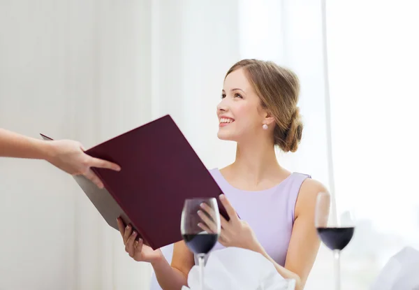 Mujer sonriente recitando el menú de camarero Imagen De Stock