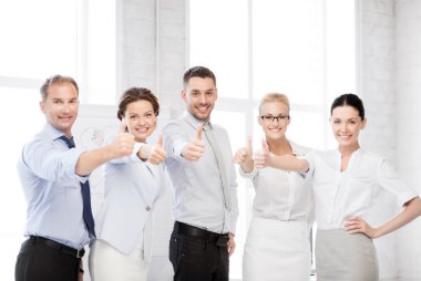 Business team showing thumbs up in office clipart