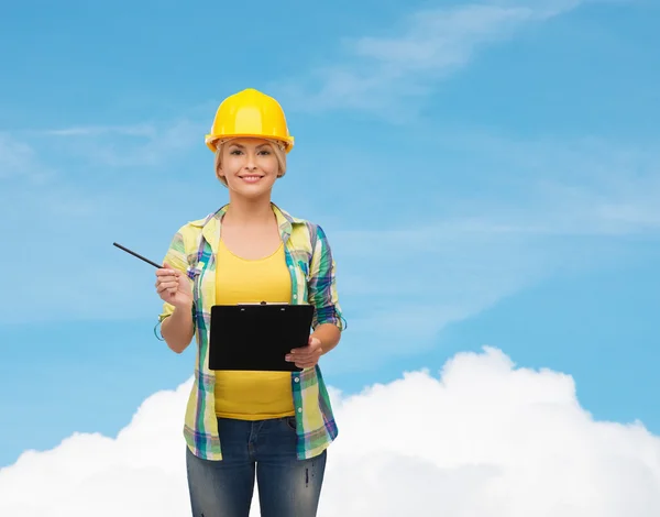 Smiling woman in helmet with clipboard — Stock Photo, Image