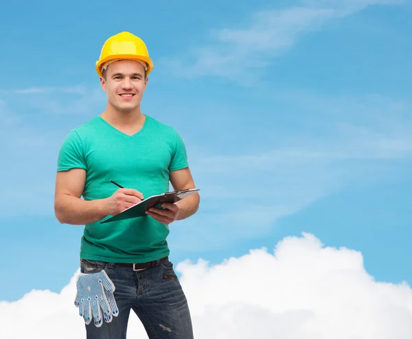 Lächelnder Mann mit Helm und Klemmbrett — Stockfoto