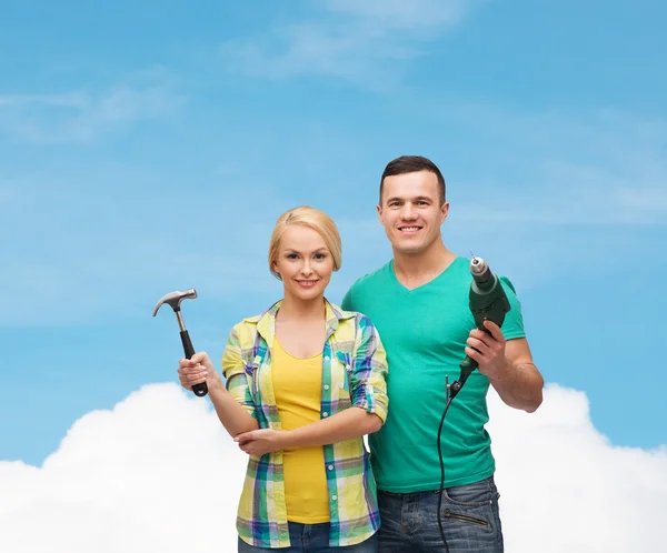 Smiling couple with hammer and drill — Stock Photo, Image