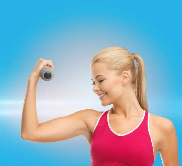 Jonge, sportieve vrouw met lichte dumbbell — Stockfoto