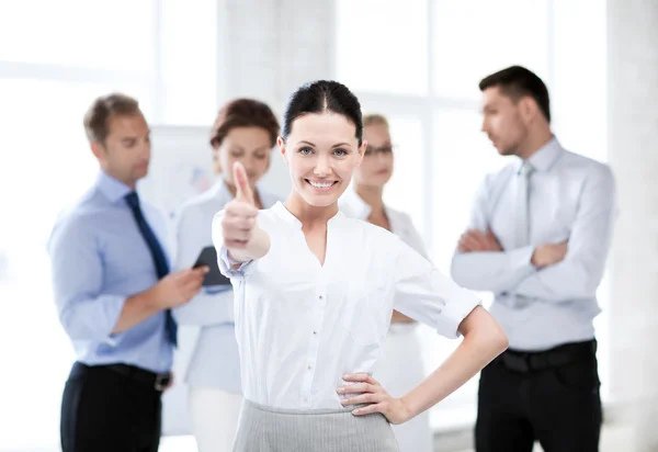 Businesswoman in office showing thumbs up — Stock Photo, Image