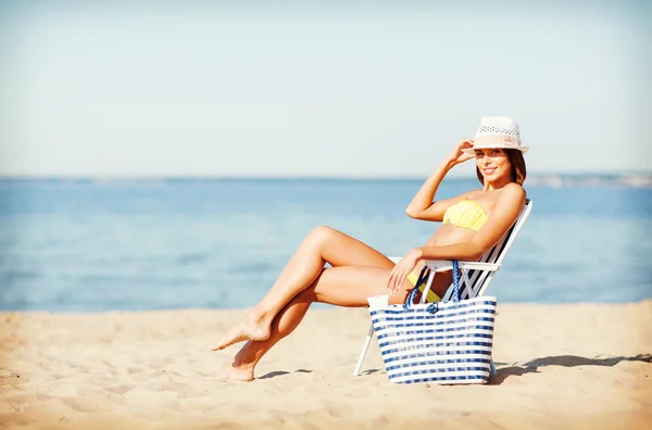 Meisje zonnebaden op het strandstoel — Stockfoto