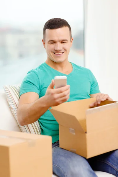 Opening cardboard box and taking out smartphone — Stock Photo, Image