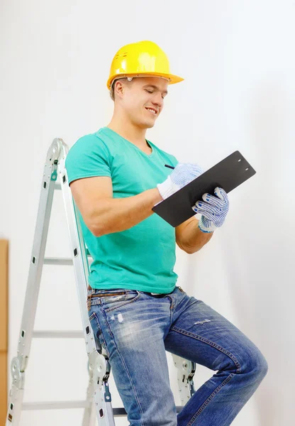 Glimlachende man in beschermende helm met Klembord — Stockfoto