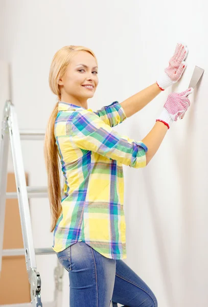 Улыбающаяся женщина в перчатках делает ремонт дома — стоковое фото