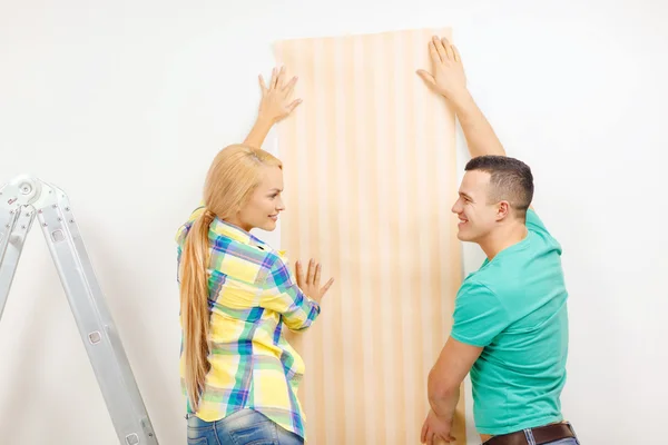 Couple souriant choisir le papier peint pour la nouvelle maison — Photo