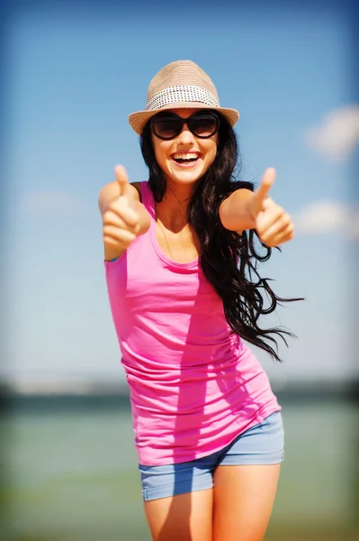 Girl showing thumbs up on the beach Stock Picture