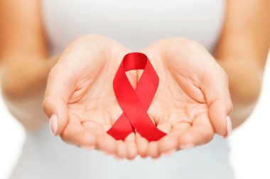 Hands holding red AIDS awareness ribbon clipart
