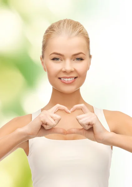 Lachende vrouw tonen hart vorm gebaar — Stockfoto