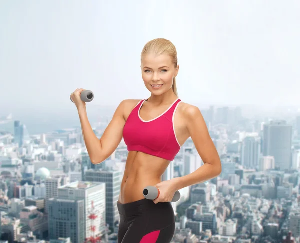 Young sporty woman with light dumbbells — Stock Photo, Image