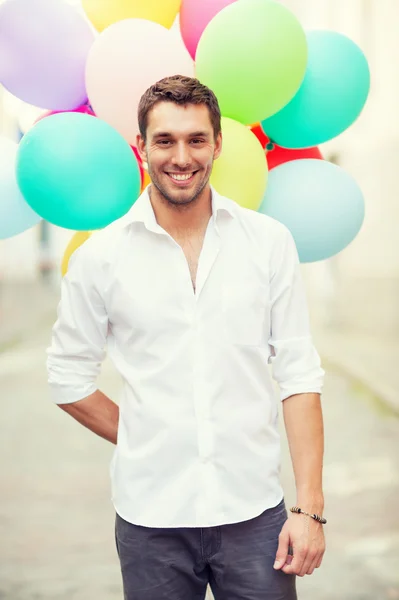 Uomo con palloncini colorati in città — Foto Stock