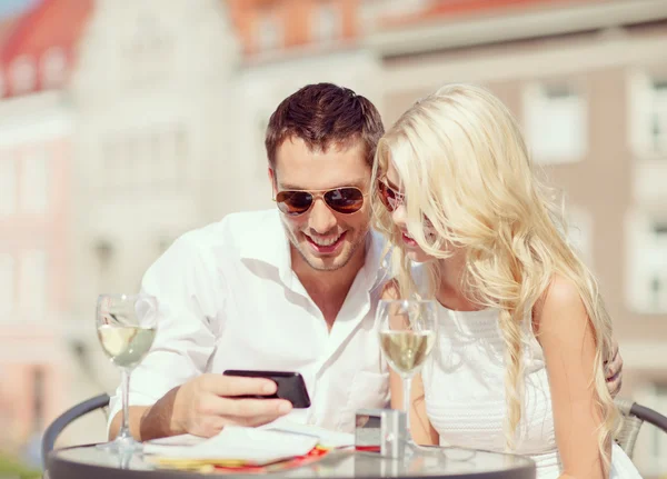 Paar kijken naar smartphone in café — Stockfoto