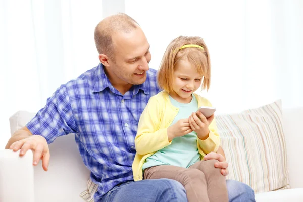 Happy father and daughter with smartphone — Stockfoto