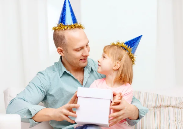 Pai e filha em chapéus azuis com caixa de presente — Fotografia de Stock