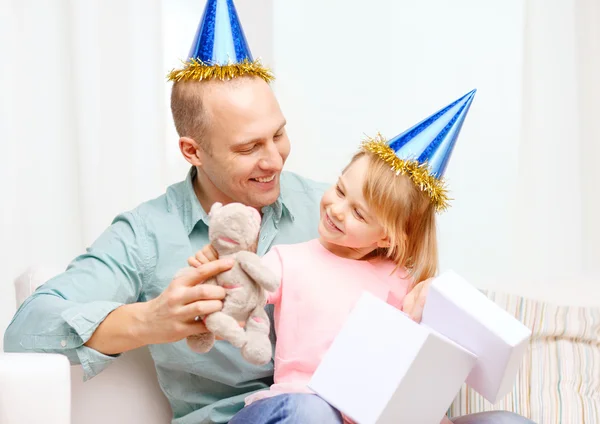Отец и дочь в синих шляпах с подарочной коробкой — стоковое фото