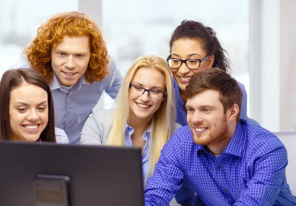 Lächelndes Business-Team beim Blick auf Computermonitor — Stockfoto