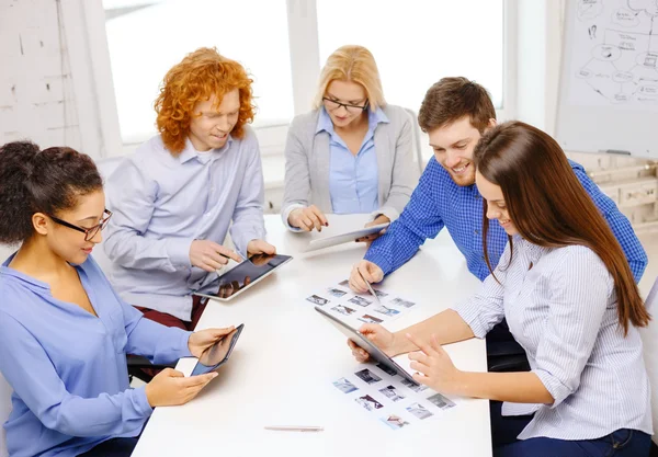 Equipe sorrindo com pc mesa e papéis de trabalho — Fotografia de Stock