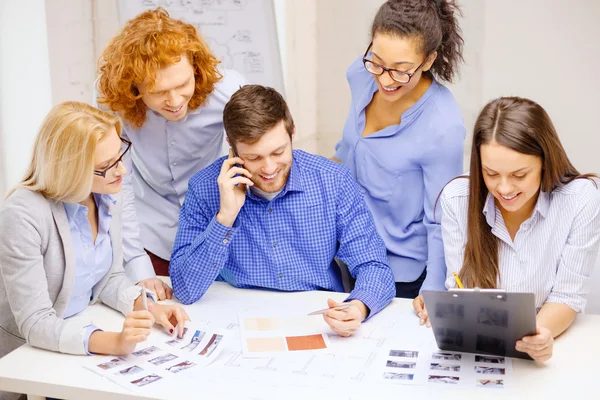 Equipe criativa com papéis e área de transferência no escritório — Fotografia de Stock